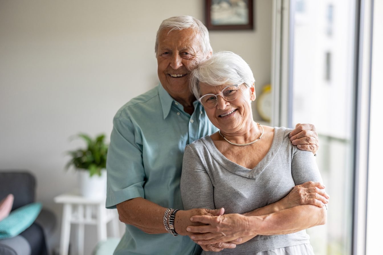 Couple de seniors souriants à leur domicile à Nîmes, environnement adapté